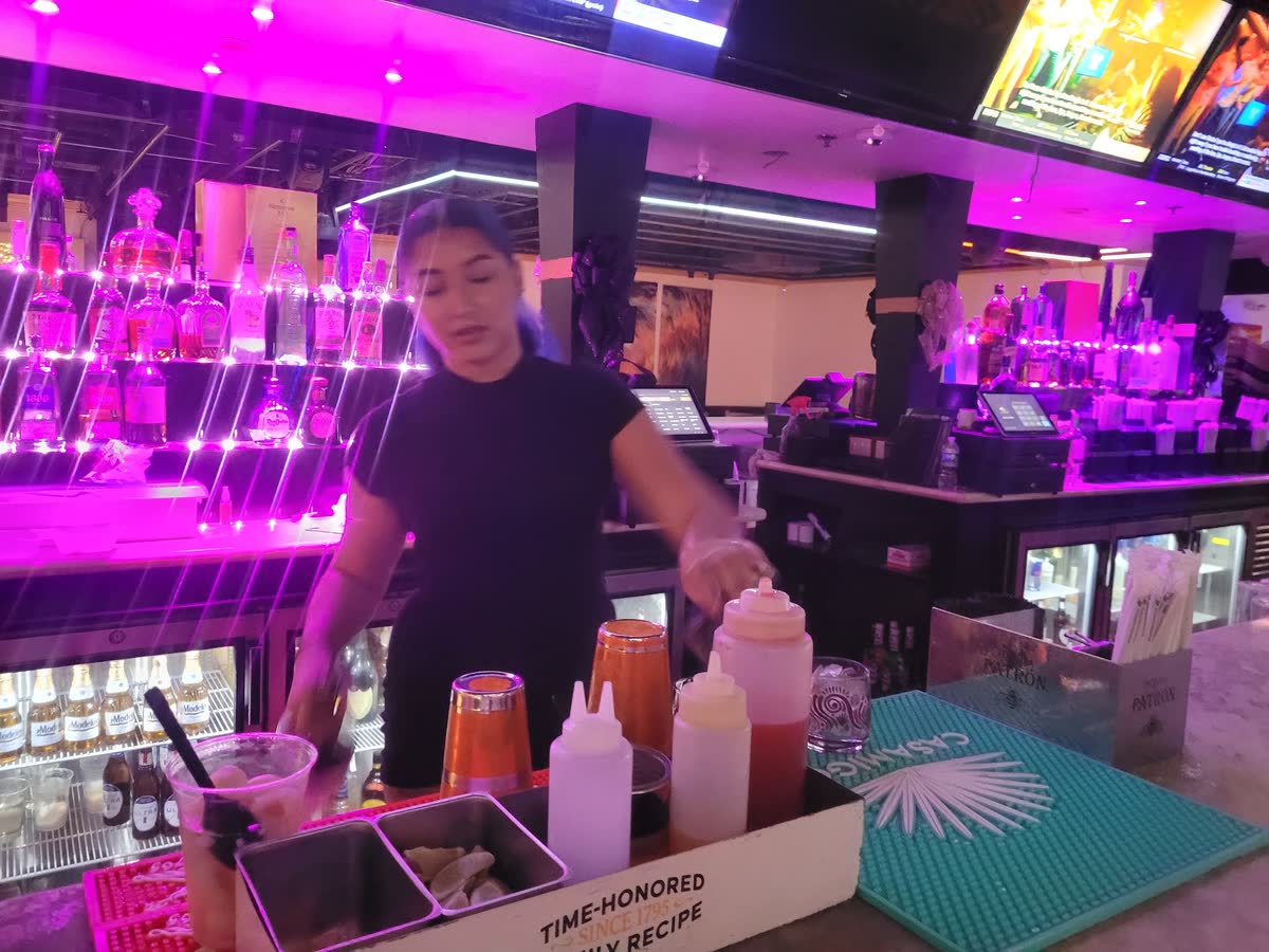 Bartender mixing drinks under pink neon at the Privé 954 bar near Hard Rock Hollywood