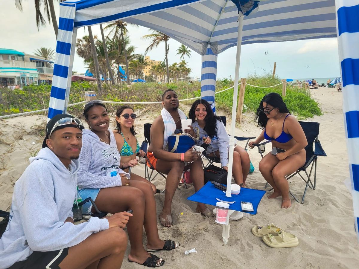 Group beach setup with cabana shade, chairs and table on Hollywood Beach FL