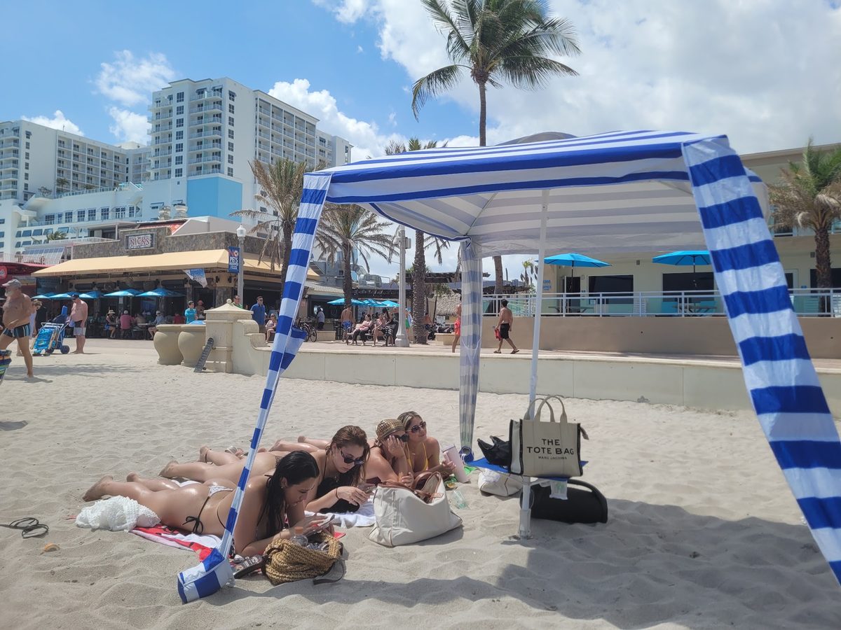 Striped beach cabana tent set up on the sand near the Hollywood Beach Broadwalk